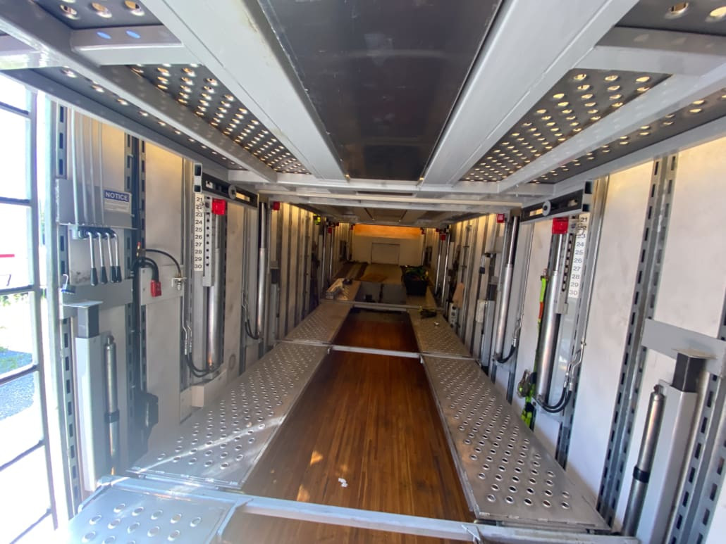 Interior view of the enclosed auto transport trailer, demonstrating the adjustable racks and spacious capacity for enclosed auto transport trailers for sale.