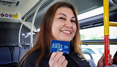 Madison Metro bus driver Lori demonstrating the Fast Fare card, a convenient payment method for Madison WI public transportation