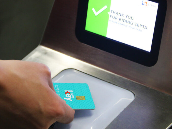 Close up of a hand tapping a SEPTA Key Card at a validator
