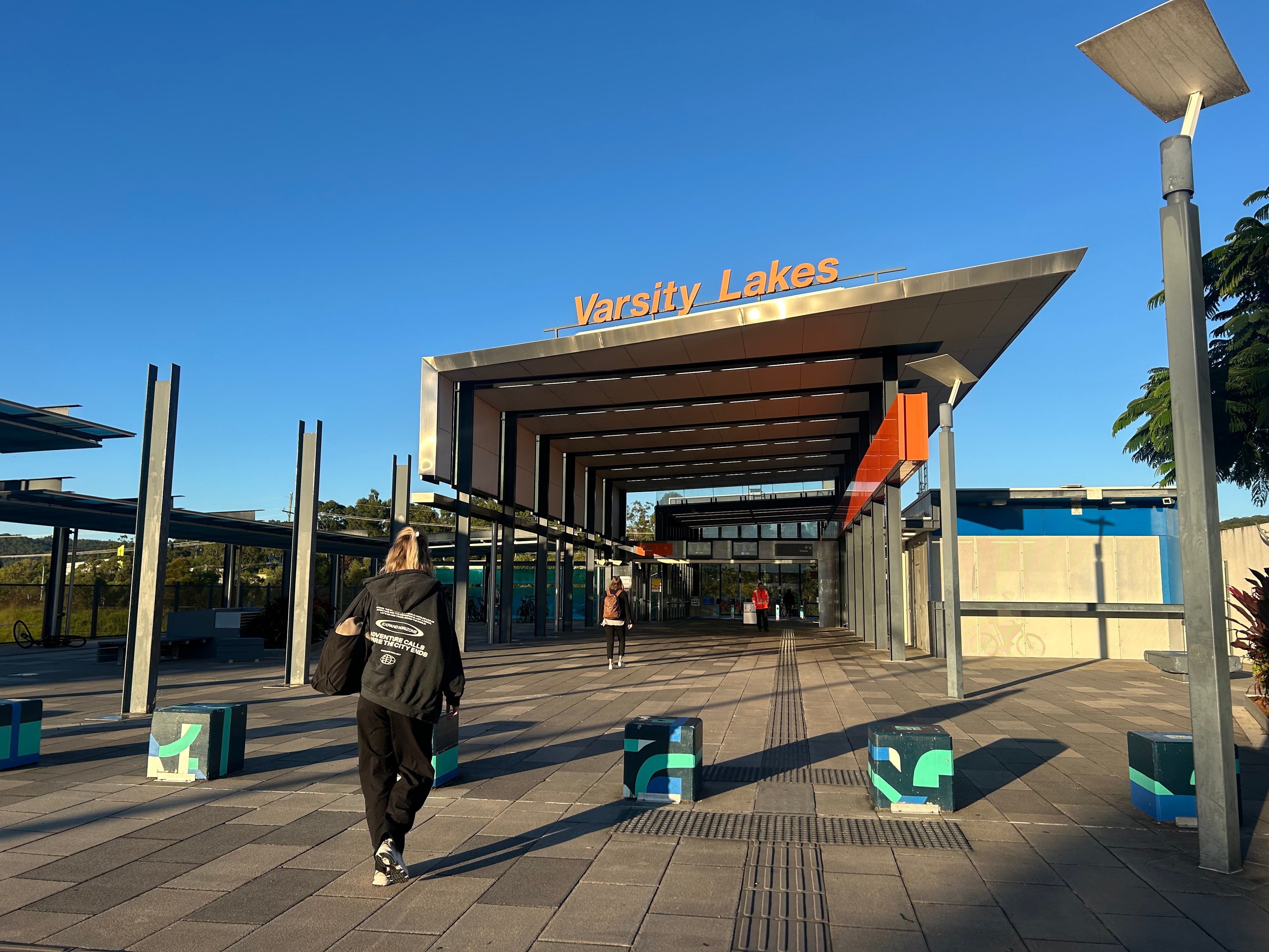 A person swipes their Go Card at a train station in Brisbane, indicating access to public transport.