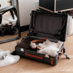 Carry-on suitcase filled packed with folded jumpers and headphones