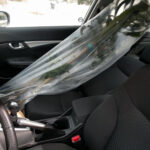 A tall Dracaena gets wrapped in plastic to prevent soil from spilling onto the floor of the car.