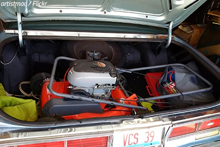 A well-secured riding lawn mower inside a rental truck, ready for transport