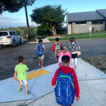 Students walking to school near a crosswalk, highlighting pedestrian safety and school transportation