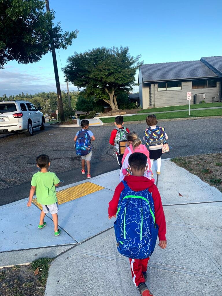 Students walking to school near a crosswalk, highlighting pedestrian safety and school transportation