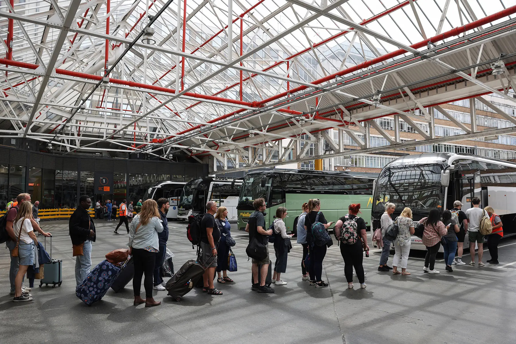 Passengers queue at Victoria Coach Station in London